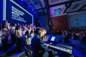 choral students perform on stage in ballroom